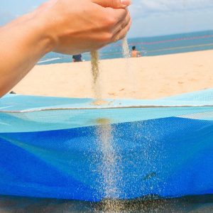 Serviette de plage double colorée étalée près de l'océan