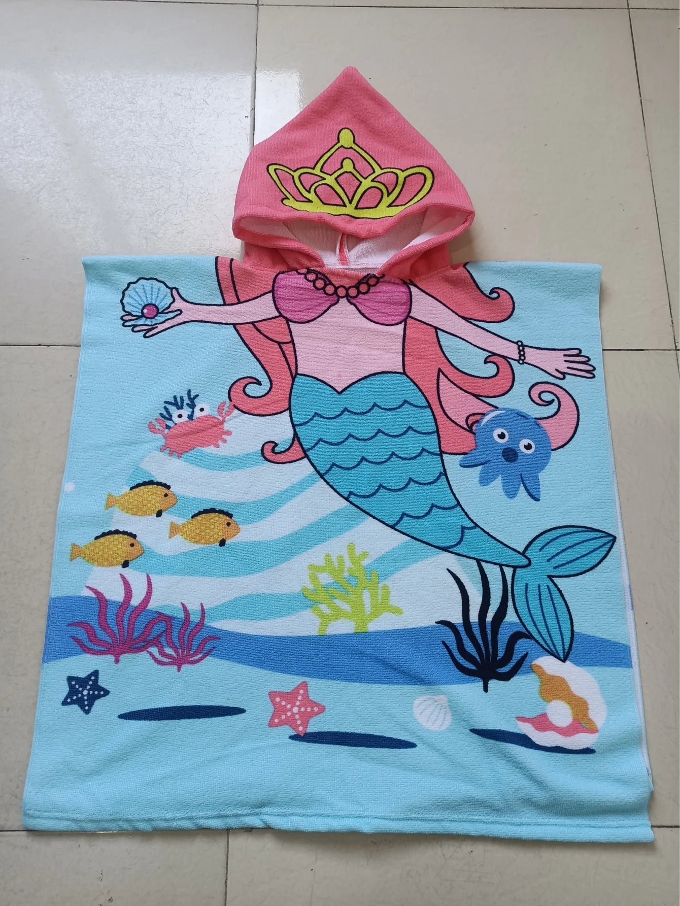 Enfant sur serviette de plage rose vif