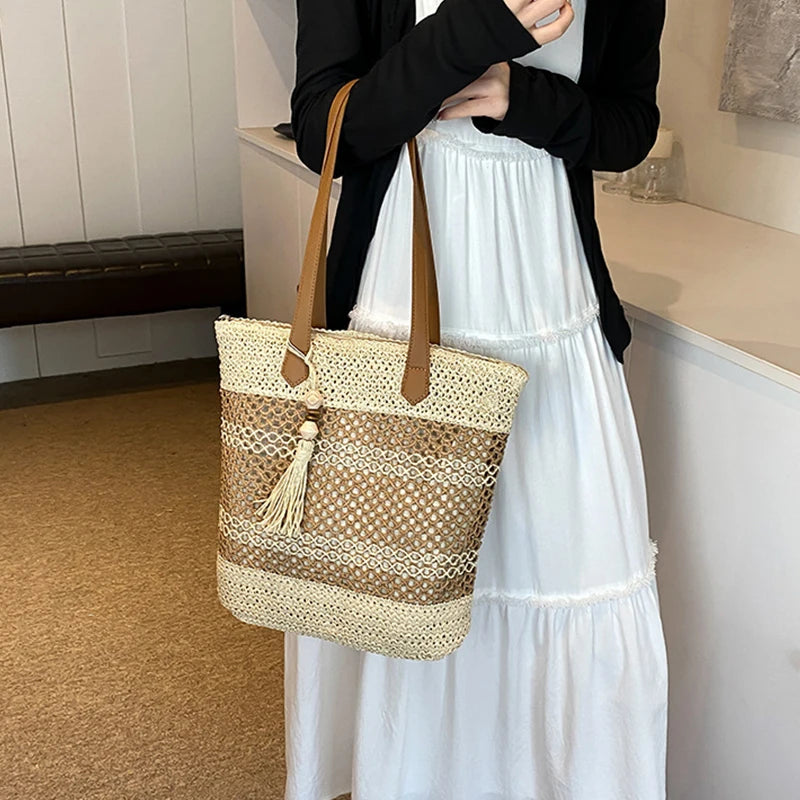 Sac de plage en paille tendance posé sur le sable
